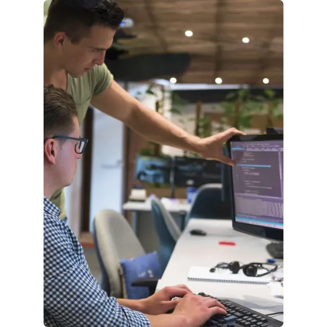 Two developers looking at secure software code on screen